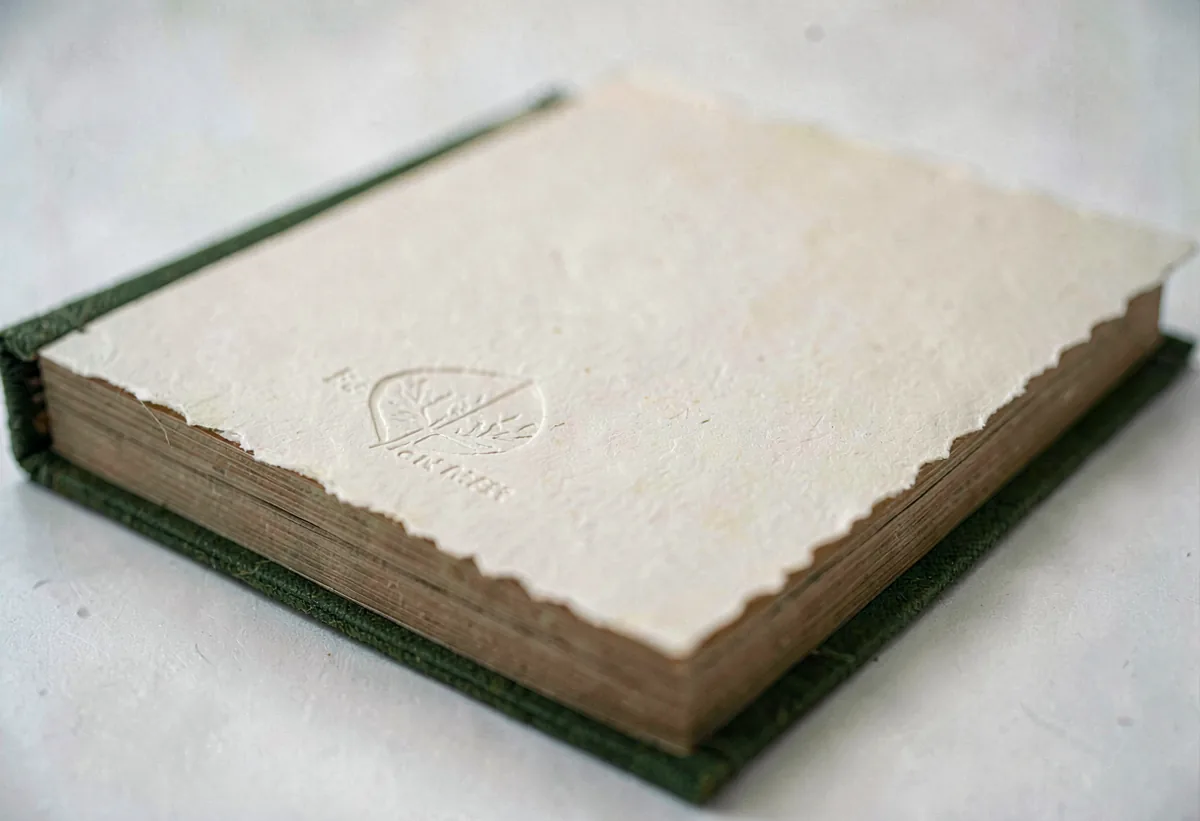 A hand-bound book with a blank deckle-edge cover and a deep-impression texture