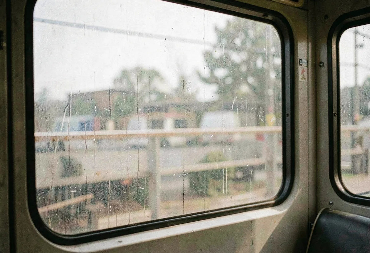 A bus window streaked with passing light