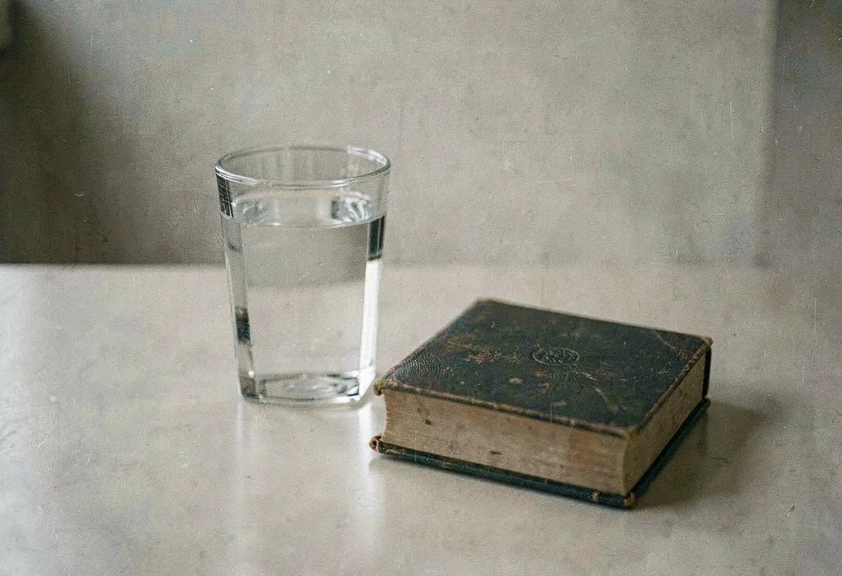 A glass of water beside a closed book