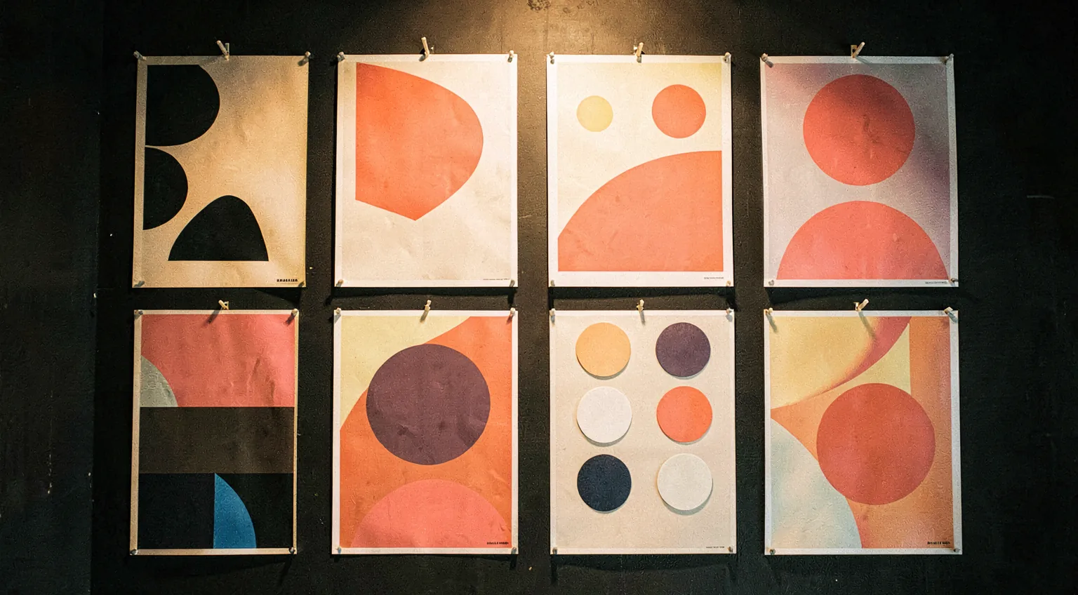 A bold studio wall of pinned brand work in warm light