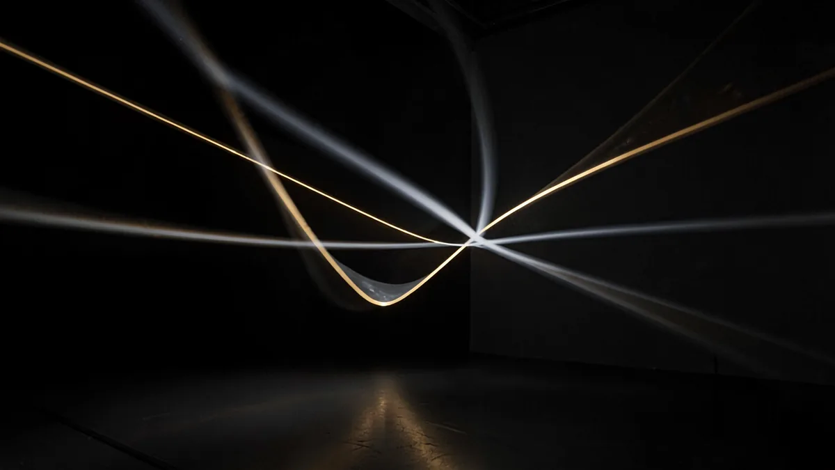 A long-exposure still of a projected light installation in a dark room