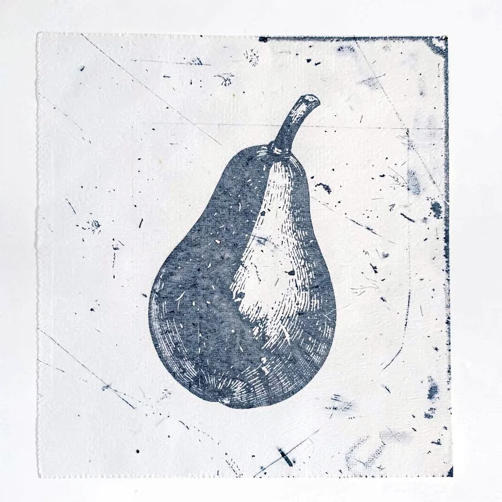 A small linocut of a single pear