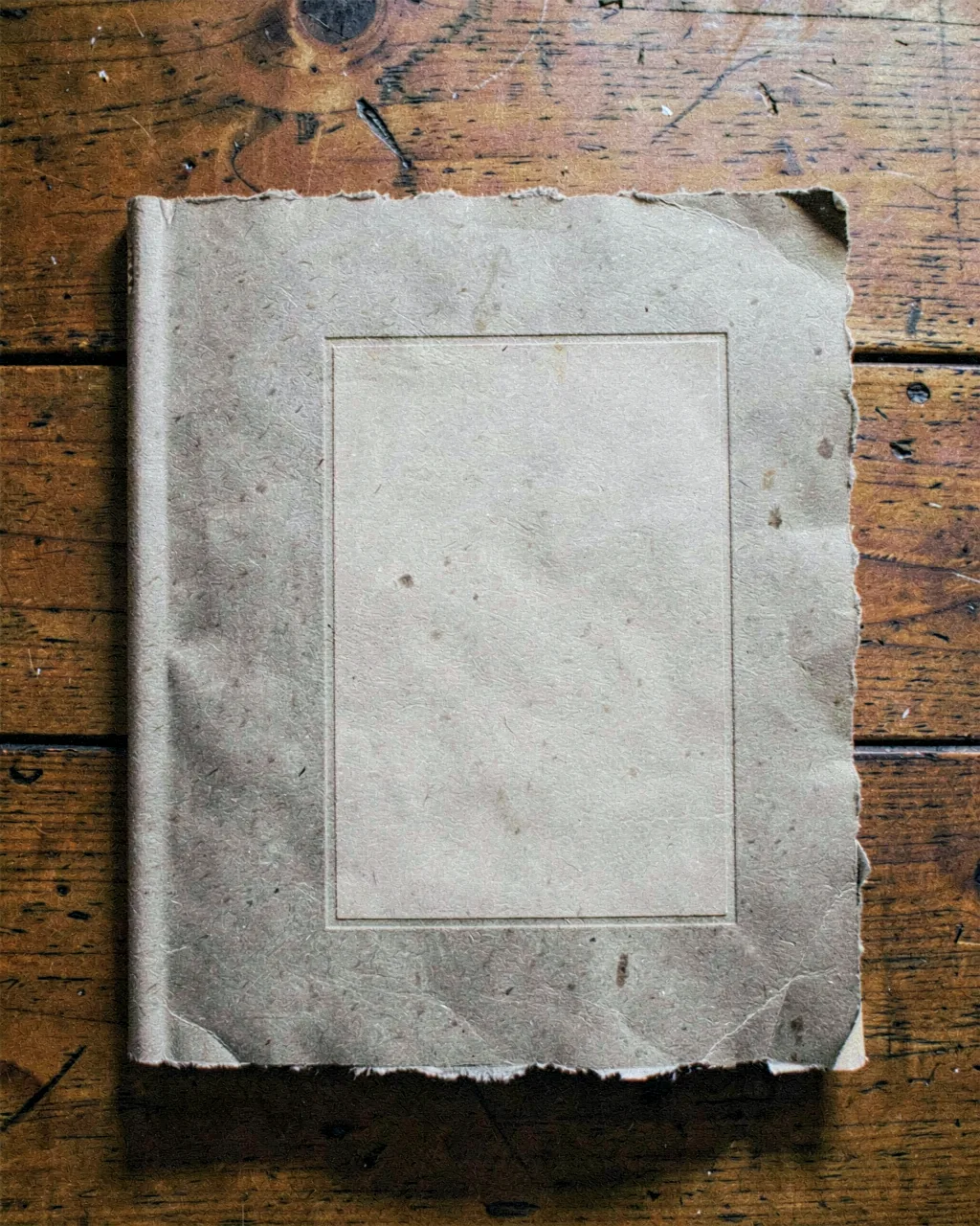 A letterpress-printed cover sheet, brick-red title on warm grey stock